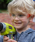 Child wearing Kids Safety Glasses ANSI Z87.1 EN166 Certified Impact Resistant Clear Lenses holding a drill
