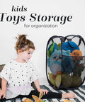 Collapsible Mesh Pop Up Hamper With Wide Opening And Side Pocket Breathable Sturdy Foldable Space Saving Design For Clothes And Home Storage Black Ideal For Apartments Dorm Rooms Travel Laundry with kids' toys inside next to a child.