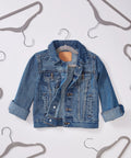 Ultra slim velvet kids hangers with non slip grip and shoulder notches displayed around denim kids jacket, perfect for compact nurseries.