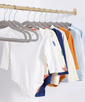 Ultra slim velvet kids hangers with non slip grip and shoulder notches keep tiny outfits neatly hung in nursery closet.