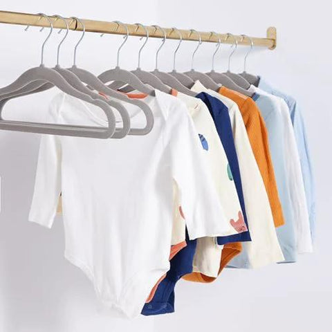 Ultra slim velvet kids hangers with non slip grip and shoulder notches keep tiny outfits neatly hung in nursery closet.