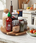 Acacia Wood Lazy Susan Turntable Organizer 8-Inch Round Rotating Serving Tray with spice bottles and condiments on kitchen counter.