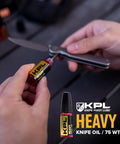 Applying knife pivot lube 75W to pocket knife for smooth operation and dirt resistance.