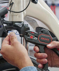 Person using Knipex Automatic Wire Stripper 10-24 AWG, 7.25 Inch Length on a bicycle cable for precise stripping.