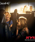 Children laughing inside minivan while man waves from outside, highlighting Excel-G Gas Shock Absorber Black for Asian Minivans OE Replacement for Honda Odyssey with Chrome Cylinder and Teflon Coated Piston Band to Restore Original Handling and Smooth Ride.