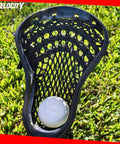 Lacrosse stick with white ball on grass, showcasing Practice Lacrosse Balls - 1, 2, 3, 6, 12, 18, 24, 36, 60 and 120 Packs - Official Size and Weight - Lime Green.