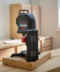 Clear room layout fast with a 360 degree three plane laser delivering bright alignment lines, shown on a wooden table.