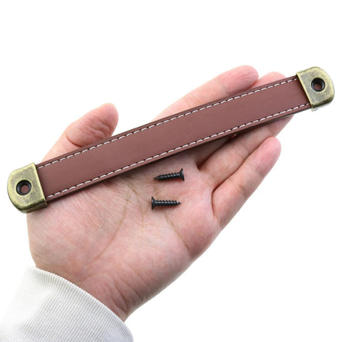 Hand holding Leather Drawer Handles Set Two Pieces 7.5 Inch Brown Luggage And Suitcase Pull Handles With Installation Screws