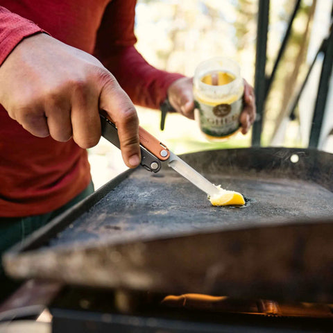 Person using Leatherman Bond 14 In 1 Lightweight Multi Tool for Camping Hiking and Everyday Carry EDC Made in USA to slice butter on grill.
