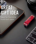 Leatherman Micra Keychain Multi Tool With Scissors And Knife on desk next to smartphone and keyboard, ideal for gifts.