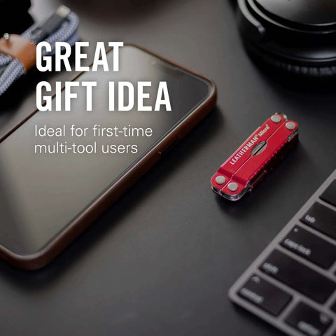 Leatherman Micra Keychain Multi Tool With Scissors And Knife on desk next to smartphone and keyboard, ideal for gifts.