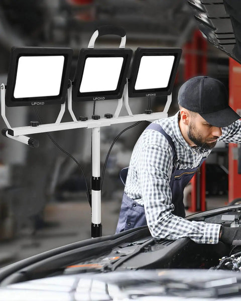 Mechanic using Ultra Bright 22000 Lumen LED Work Light With Stand, 3 Head Portable Work Lamps, Waterproof Metal Telescoping Tripod