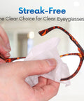 Lens cleaning wipe used to clean tortoiseshell eyeglasses; close-up view