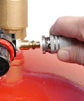 Close-up of hand connecting hose to Lincoln 3601 Pneumatic 18 Gallon Pressurized Fluid Drain and Evacuation Tank, red top visible.