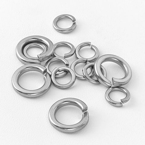 M10 Split Lock Washers 304 Stainless Steel Pack Of 50 scattered on a white surface