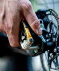 M17 Gold Bicycle Multi Tool in hand during bike repair, showing hex and spoke wrenches, close-up on ergonomic grips