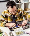 Man building a computer with 320Pcs M3 Motherboard Standoffs Screws Nuts Kit, includes brass spacer standoffs for DIY projects and electronics.