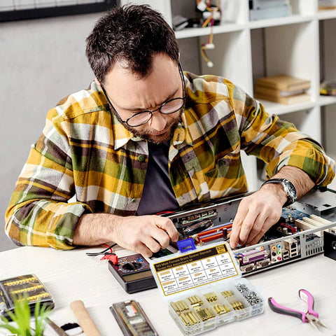 Man building a computer with 320Pcs M3 Motherboard Standoffs Screws Nuts Kit, includes brass spacer standoffs for DIY projects and electronics.