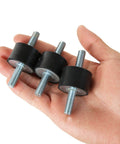 Hand holding three Eight M8 Rubber Vibration Isolator Mounts Cushion Machinery Absorb Shocks Reduce Noise And Protect Air Compressors