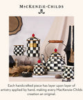 Mackenzie-Childs ceramic kitchenware set with black and white courtly check pattern, teapot, cups, and canisters on a table