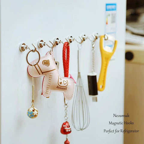 Refrigerator with multiple magnetic hooks holding kitchen utensils and decorative items, highlighting versatility and organization.