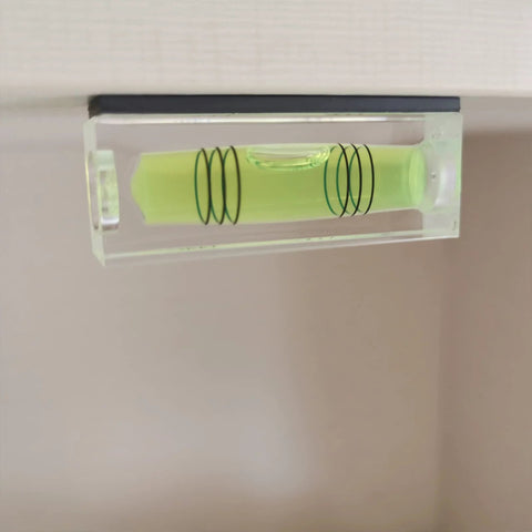 Close-up of a magnetic bubble level tool set showing green liquid vial for precise leveling in carpentry and DIY projects.