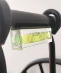 Close-up of magnetic bubble level tool set on metal frame.