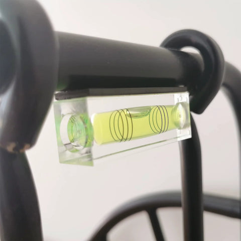 Close-up of magnetic bubble level tool set on metal frame.