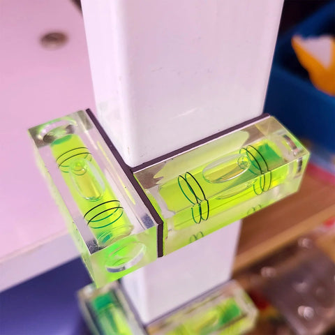 Magnetic Mini Bubble Level Tool Pack, Pocket Size, Ultra Precise 3Line Grid in use on white furniture for horizontal alignment