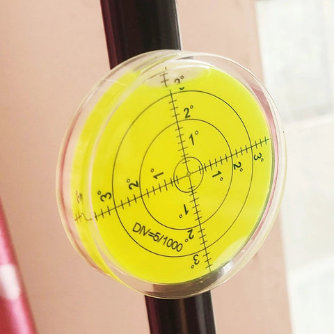Magnetic Round Bubble Level Tool Pro Grade Bullseye Inclinometer for Machinists and DIY Enthusiasts attached to a metal rod.