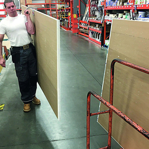 Worker carrying plywood using the JawClaw Panel Gripper for Plywood, Drywall and Steel Sheets, ensuring smooth motion and alignment.