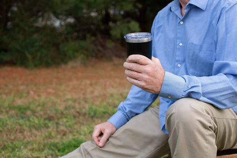 Person holding Double Wall Vacuum Insulated Travel Tumbler 20 Oz Keeps Drinks Hot Or Cold For Hours with magnetic slide lid outdoors