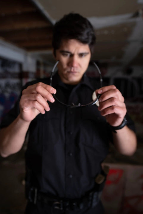 Man examining Harrier Interchangeable Shooting Glasses With 4 Lens Sets And Anti Fog Lenses indoors.