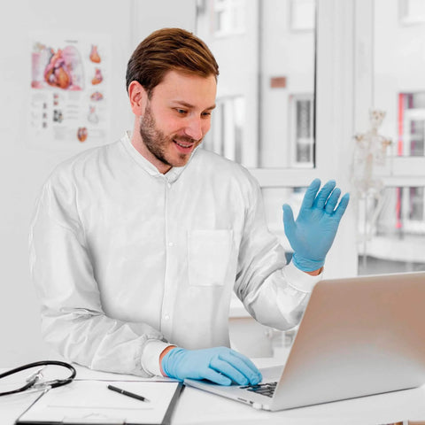 Man wearing Disposable Lab Coats For Adults Medium Pack Of 10 White Knee Length With Knit Collar Cuffs Plastic Snaps And 3 Pockets 50 GSM SMS