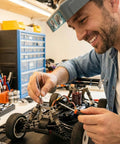 Man using Shim Washers Stainless Steel 3x5 Precision Spacer Kit for RC tuning in workshop with RC car