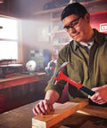 Person using 20 oz steel general purpose hammer with an ergonomic vibration-reducing grip, smooth face, one-piece forged design