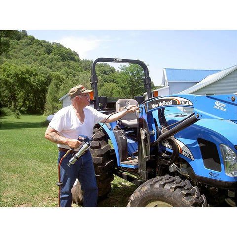 Man using Heavy Duty Pneumatic Grease Gun With 30 Inch High Pressure Hose And 6000 PSI Power on blue tractor in farm setting