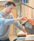 Man wearing 48 Pack Safety Glasses Clear Protective Eyewear For Work Lab Lightweight Comfort operating a power saw.