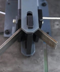 Top view of a manual steel bending brake in use, showing 90-degree bend on steel with bench top mount. Manual Steel Bending Brake With Four Inch Capacity And 2.5 Ton Press Bench Top Mounted 90 Degree Bender For Three Sixteenth Inch Steel And Three Eighth Inch Aluminum.