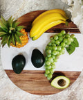 Large Marble And Acacia Wood Lazy Susan Turntable Rotating Serving Tray with bananas, grapes, avocados, and pineapple