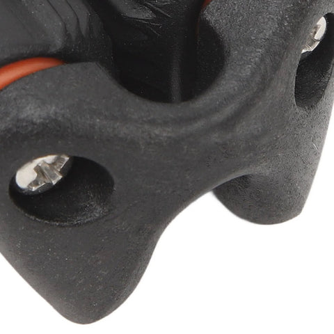 Close-up of black nylon ball bearing cam cleat with orange rope and mounting screws.