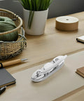 Folding stainless steel boat cleat, 4.5-inch, chrome finish, displayed on a wooden desk.