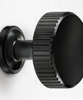 Side view of a 20-Pack Matte Black Cabinet Knob for Kitchen Cabinets and Drawers, Dresser, Bathroom, made of solid zinc alloy, brushed finish.