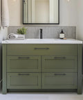 Green vanity with 12 Pack Matte Black Cabinet Pulls 5 Inch Center To Center Handles For Cabinets And Dressers in a bathroom setting.