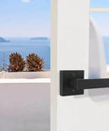 Matte Black Square Dummy Door Lever on white door with sea view, part of 4 Pack For French Doors And Closet Hardware Non Turning Exposed Screws