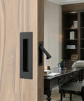 Matte Black Stainless Steel Pocket Door Pull And Edge Pull Set installed on a recessed sliding door in home office