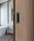 Matte Black Stainless Steel Pocket Door Pull And Edge Pull Set for Recessed Sliding Doors, installed, highlighting flush mount design.