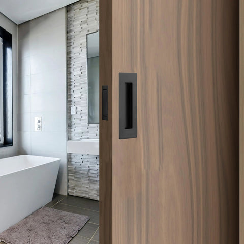 Matte Black Stainless Steel Pocket Door Pull And Edge Pull Set for Recessed Sliding Doors, installed, highlighting flush mount design.
