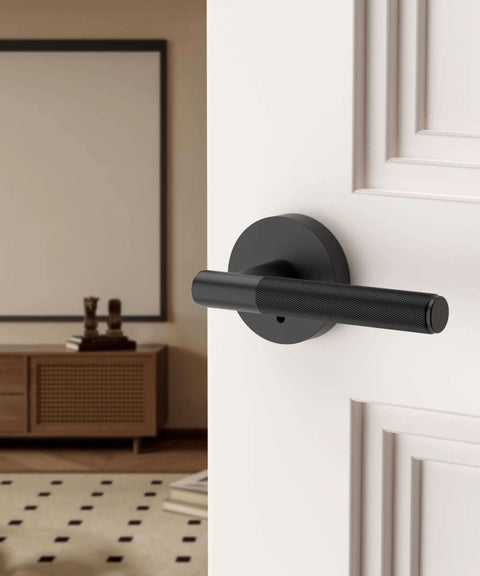 Matte black privacy door handle with lock on a white interior door, part of a 4 pack for bedrooms or bathrooms, reversible and keyless.