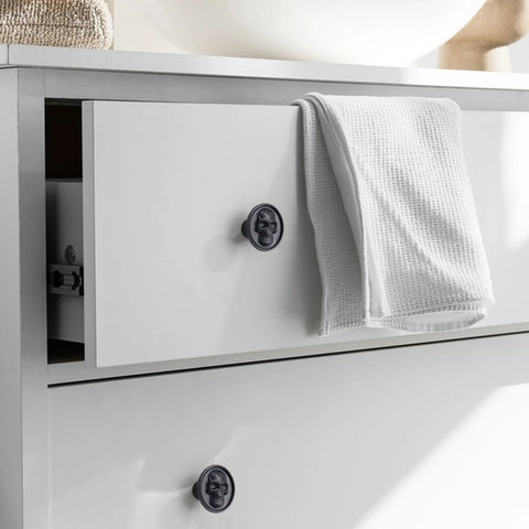 Matte Black Zinc Skull Cabinet Knobs For Drawers Doors And Furniture Hardware on white dresser with towel, two screw lengths visible